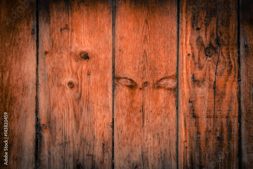 Fototapeta Old rural wooden wall in dark brown and orange colors, detailed plank photo texture. Natural wooden building structure background.