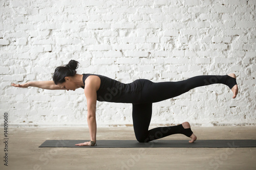 Poster Young yogi attractive woman practicing yoga concept, standing in Donkey, Kick ex