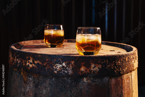 Glass of whiskey on wooden background close up