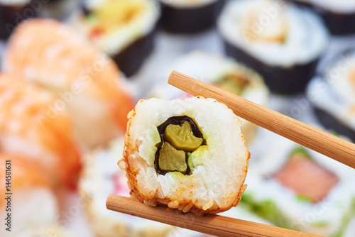 Sushi set. Chopsticks with portion of sushi