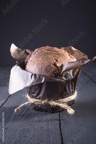 Poster Chocolate cupcake on the table. Dark background. Place for text