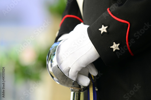 Poster Carabiniere vestito in alta uniforme tiene con due mani la spada