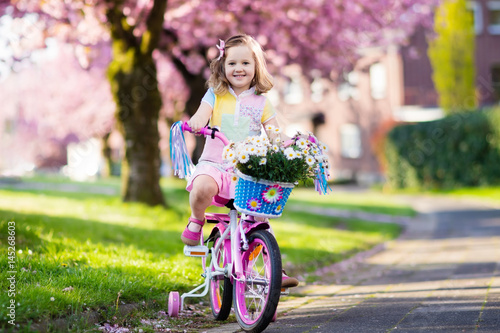 Little girl riding a bike. Child on bicycle.