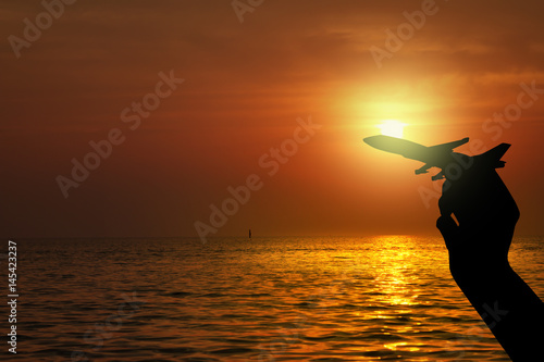 Silhouette of hand holding airplane , Travel concept