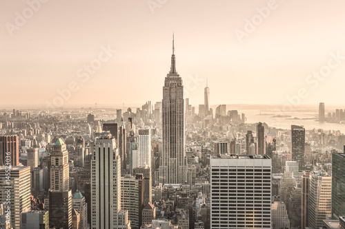  New York City. Manhattan downtown skyline with sun illuminated Empire State Building and skyscrapers at sunset.