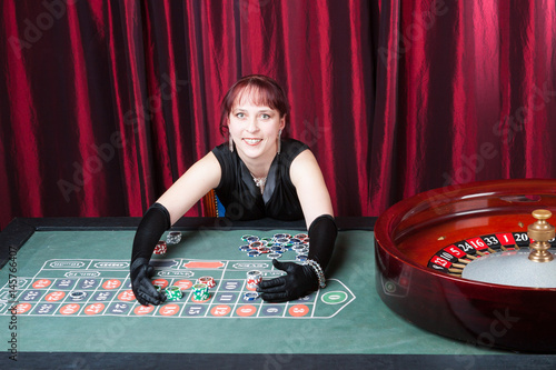 young woman wearing black gloves and black dress wins in a casino Obraz na płótnie