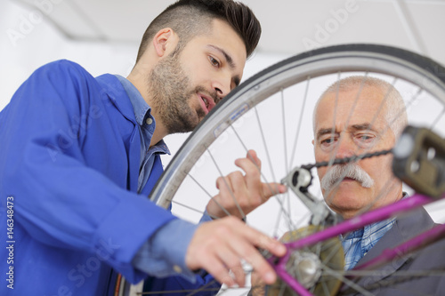 Men looking at bicycle chain