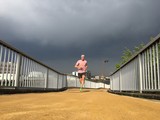 Male runner on path with storm clouds behind 
