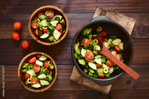 ensalada-fresca-de-aceitunas-negras-y-verdes-tomates-cherry-pimiento-verde-y-pepino-sazonados-con-sal-pimienta-oregano-seco-y-albahaca-fotografiados-sobre-madera-oscura-con-luz-natural