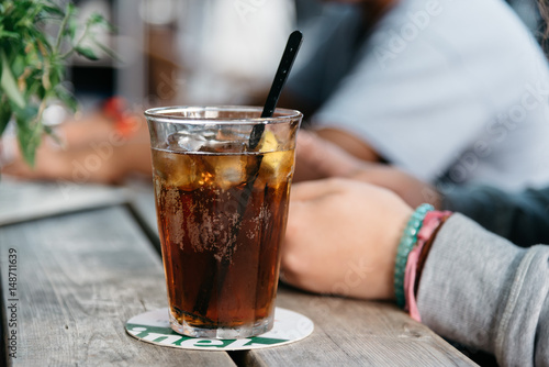 Refreshing glass of cola on wooden table in a bar Poster