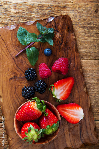 strawberry and berries on wooden cutting board