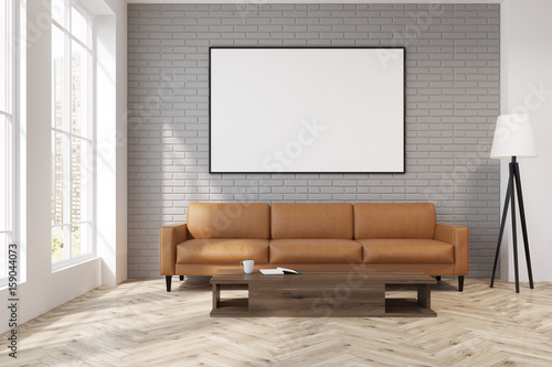 Fototapeta Gray living room with a beige sofa, poster, lamp
