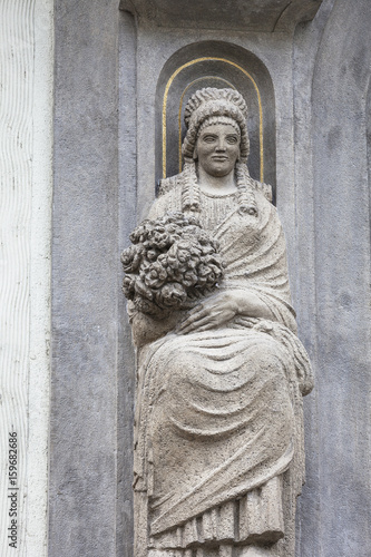 Poster Statue on facade of old building, woman with a bouquet of flowers, Prague, Czech Republic