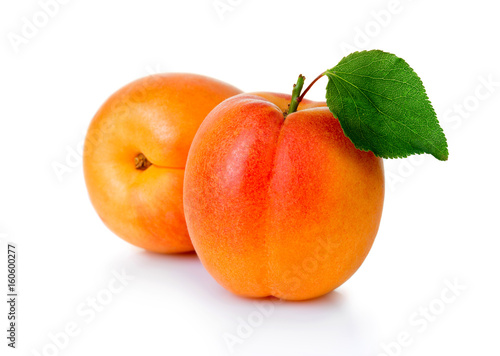 Ripe apricot fruits with green leaf isolated on white © Serhiy Shullye
