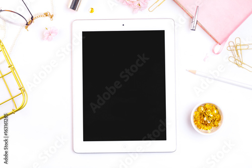 Workplace mockup with pink leather notebook, glasses, white tablet and golden accessories on white background top view. Flat lay with copy space. Feminine working style concept.