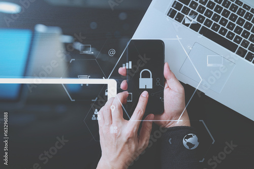 cyber security internet and networking concept.Businessman hand working with VR screen padlock icon mobile phone on laptop computer and digital tablet © everythingpossible
