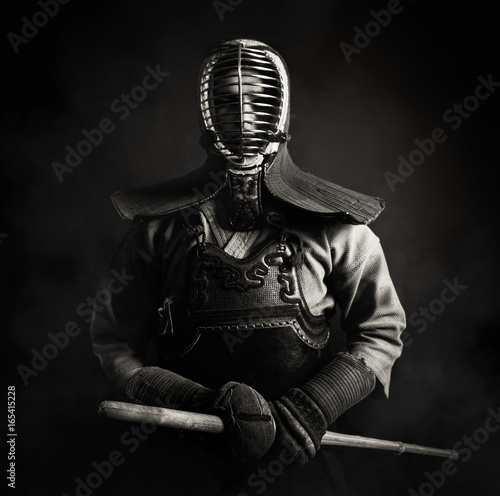 kendo-maestro-de-pie-en-armadura-tradicional-el-sostiene-la-espada-de-bambu-shinai