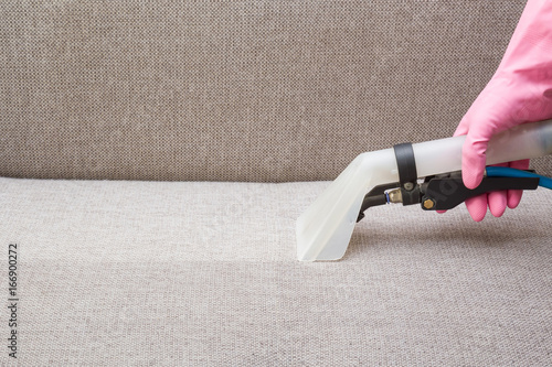 Sofa Chemical Cleaning With Professionally Extraction Method Hand Sofa Chemical Cleaning With Professionally Extraction Method Hand In Rubber Protective Glove Holding Nozzle Of
