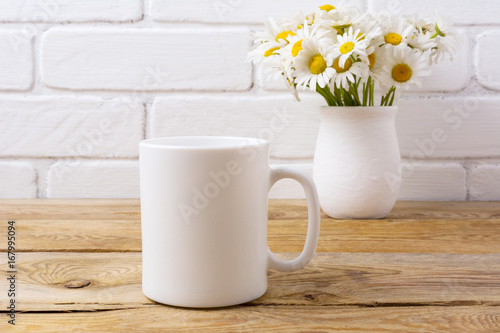 White coffee mug mockup with chamomile bouquet in rustic vase