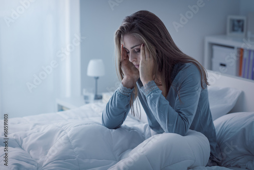 Depressed woman awake in the night, she is exhausted and suffering from insomnia