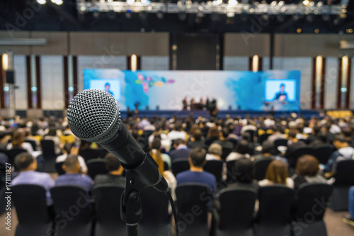 Microphone with Abstract blurred photo of conference hall or meeting room with attendee background, business and education concept © THANANIT