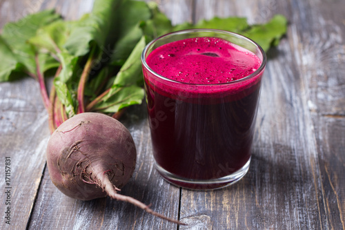 Fresh beet juice in glasses with a straw on a wooden background, selective focus. Healthy detox diet © olepeshkina