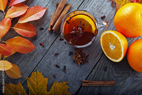 heiser-tee-mit-gewurzen-und-orange-inmitten-herbstlaub