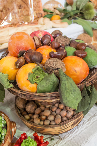 Autumn background with fruits, kaki, chestnuts, pomegranates, hazelnuts and nuts