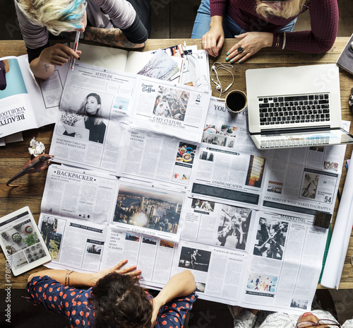 Colleagues discussing newspaper articles