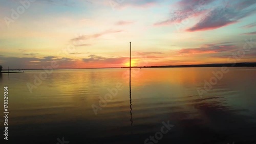 Wide drone shot flying across beautiful lake during sunset