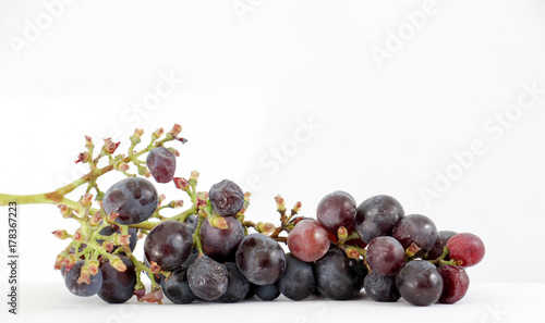 Black grapes with drop of water isolated on white background.