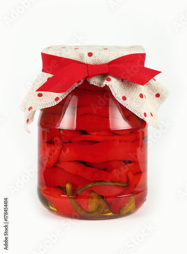 Jar of pickled red hot chili peppers over white