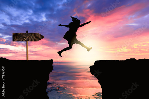 courageous and motivated woman jumps the crevasse