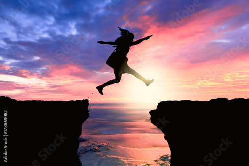 courageous and motivated woman jumps the crevasse