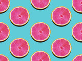 Grapefruit in flat lay Fruity pattern of grapefruit with pink flesh on a turquoise background Top view Modern flat lay photo pattern in pop art style