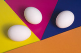Easter eggs on a multicolored background of yellow, blue, pink and orange