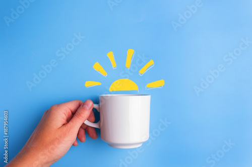 sun and white cup on blue background