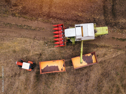 Aerial view of combine pouring harvested corn grains into trailer © Bits and Splits