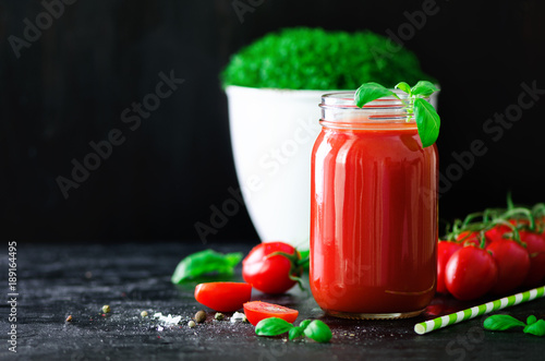 organischer-frischer-tomatensaft-in-einem-glasgefas-in-einem-basilikum-in-einer-kirsche-in-einem-salz-in-einem-pfeffer-und-in-einem-stroh-auf-dunkelschwarzem-hintergrund-sauberes-essen-und-diatkonzept-kopieren-sie-platz
