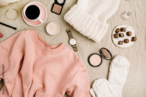 Female fashion look with stylish clothes and accessories. Lifestyle flat lay, top view composition with sweatshirt, cosmetics and coffee.