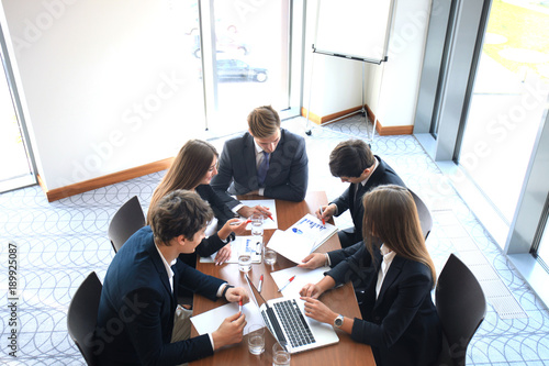 Business meeting in an office, the businesspeople are discussing a document.