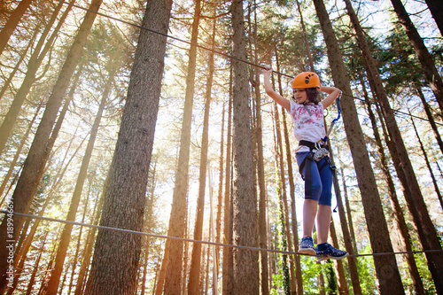 bambina in equilibrio sul percorso del parco avventura