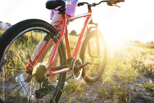 chica-joven-con-una-bicicleta-deportiva-en-la-luz-del-sol