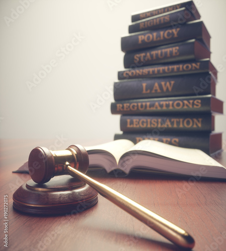 Wooden hammer with gold details and books in the background.