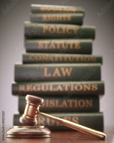 Wooden hammer with gold details and books in the background.