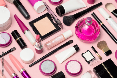 Set of makeup cosmetics, brushes, concealer and other essentials on pink background © Anastasiia