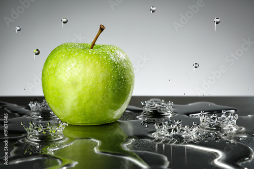 Green apple with water drops on grey background © i_arnaudov