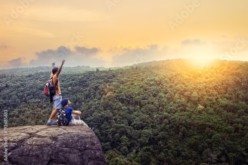 couples-de-voyage-homme-et-femme-se-detendre-au-sommet-de-la-haute-montagne-avec-beau-ciel-coucher-de-soleil-derriere-la-montagne-verte