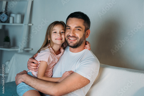 portrait-de-souriant-pere-et-fille-regardant-la-camera-a-la-maison