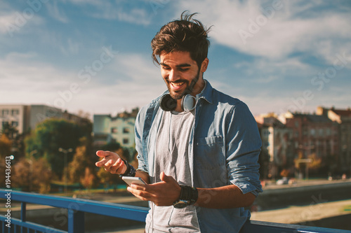 Young happy man using a smartphone in the city © djile